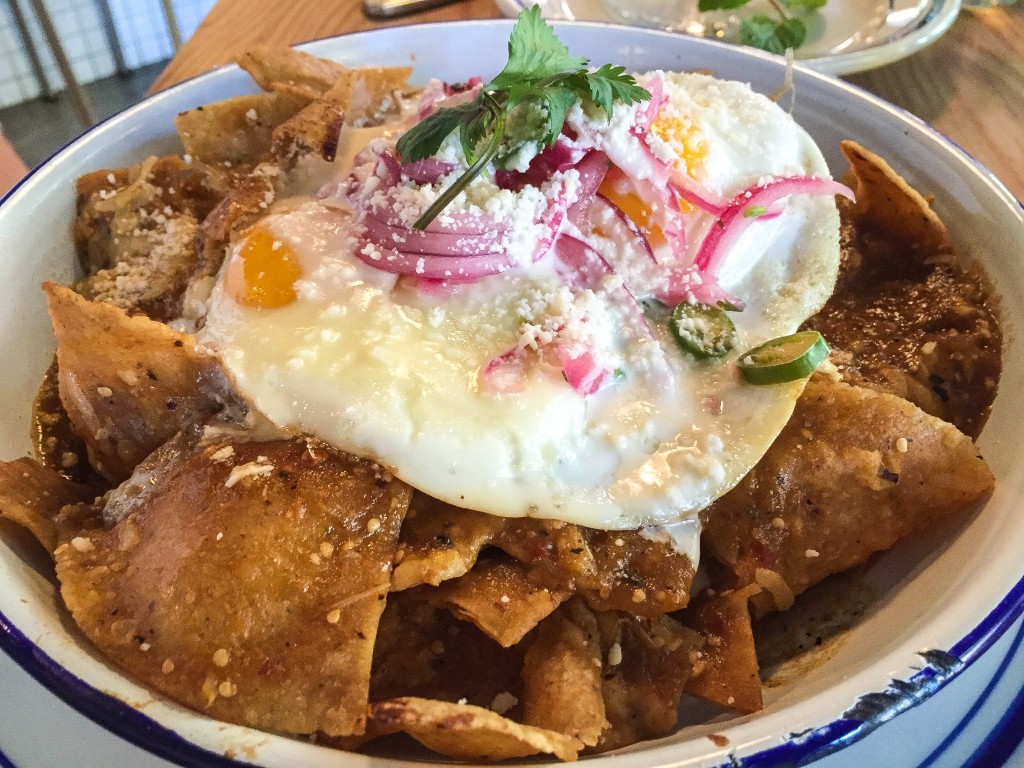 Chilaquiles - sunnyside eggs, smokey roasted tomatillo salsa, Chihuahua cheese, tortilla chips, pickled jalapenos & red onions - $14