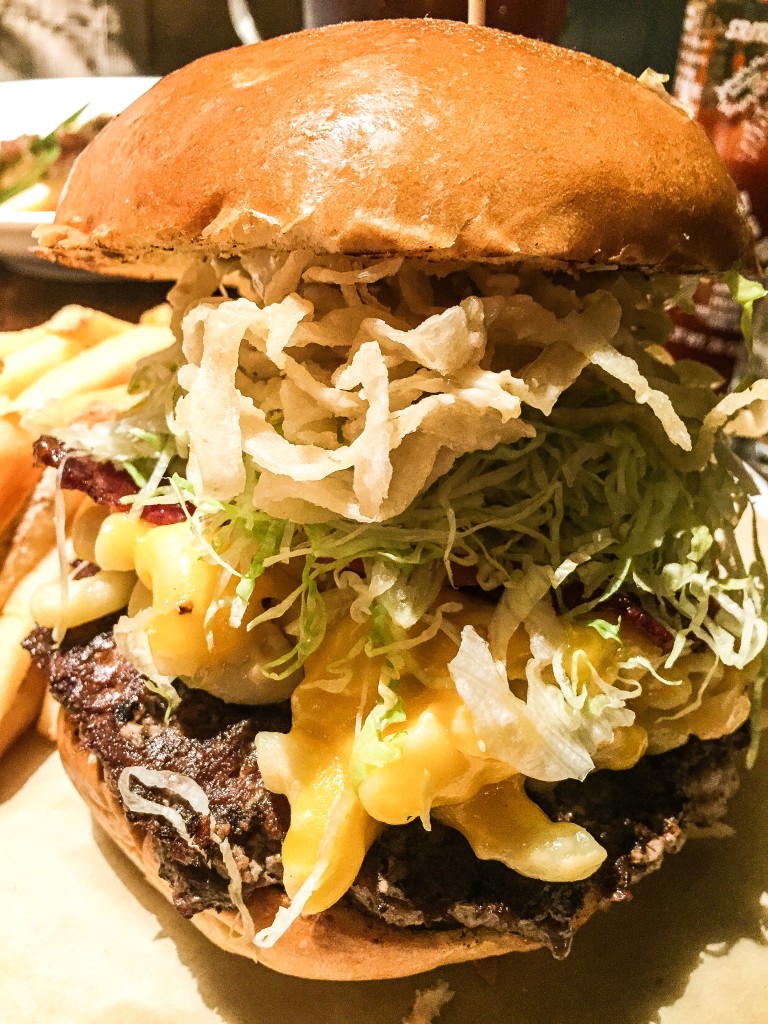 Bacon Mac n Cheese Burger - $18.50 Crispy applewood smoked bacon, creamy four-cheese mac n cheese, all-natural signature blend ground beef, lettuce, tomato, onion, pickle, donkey sauce + garlic butter on toasted brioche