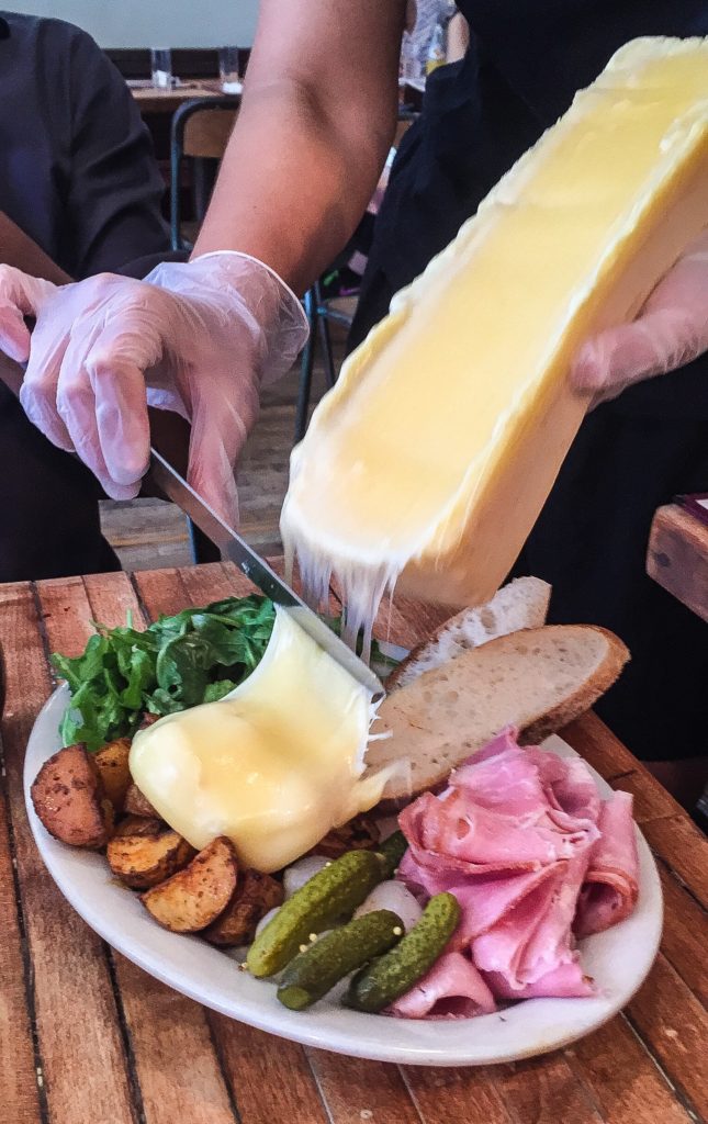  Suisse   $18.00/Regular $23.00/Large Add $4 for Raw Cheese   Raclette cheese, melted and scraped tableside; choice of viande séchée, prosciutto di Parma OR jambon de Paris; roasted potatoes; cornichons; pickled white pearl onions; sliced baguette; arugula salad with champagne vinaigrette  